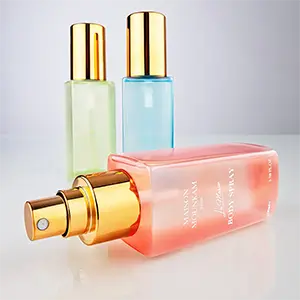 Eine rote Flasche Body-Spray im Vordergrund quer liegend mit zwei weiteren Flaschen in grün und blau im Hintergrund. Ein kurzer Aufnahmeabstand sorgt für eine dynamische Perspektive. Studio für Produktfotografie Klaus Ohlenschläger