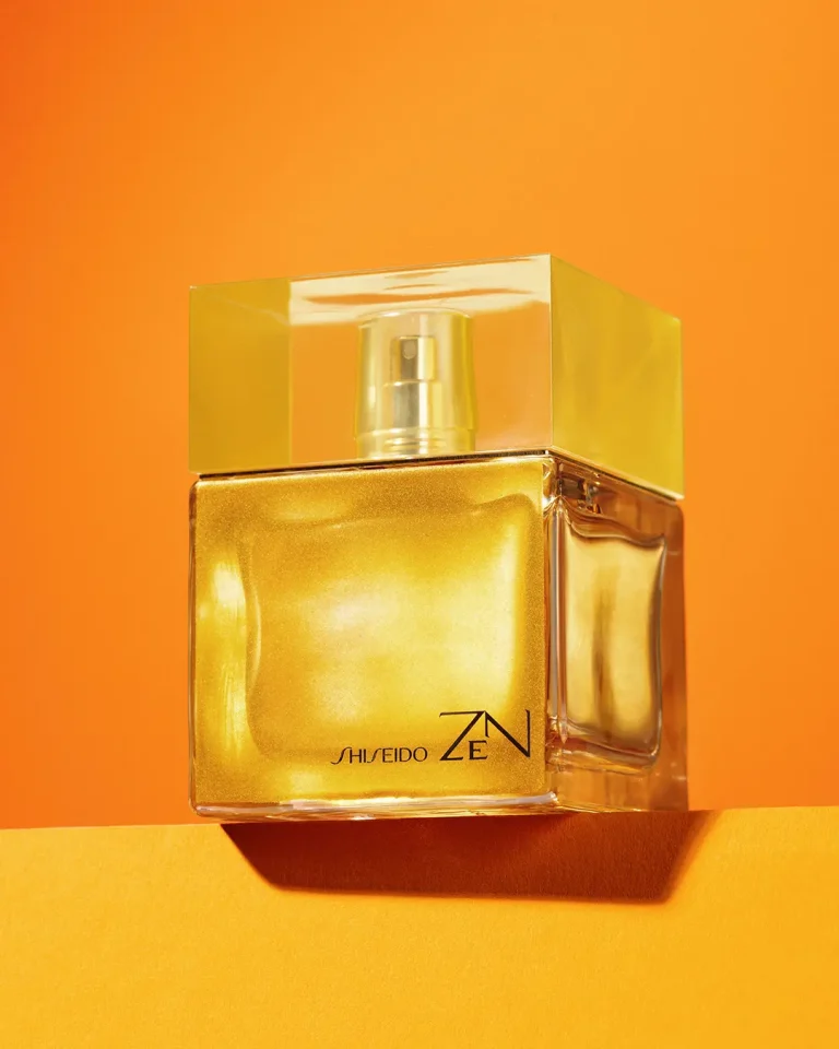 Parfumflakon als Heroshot vor orangefarbenem Hintergrund mit harten Schatten. Produktfotografie Klaus Ohlenschläger, Frankfurt-Kronberg